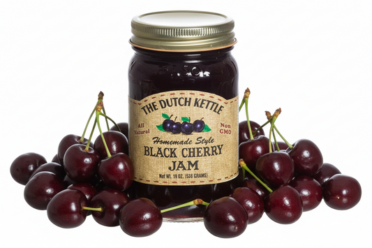 Jar of Dutch Kettle Black Cherry Jam with a gold lid on a white background
